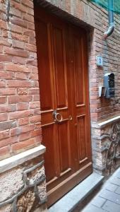 una puerta de madera en el lateral de un edificio de ladrillo en da nico en Orbetello