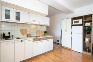 多納瓦利的住宿－ALURE RESIDENCES 4 & 24h self check-in，厨房配有白色橱柜和白色冰箱。
