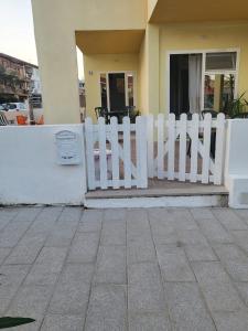 a white picket fence in front of a house at Casa Giagoni in Santa Teresa Gallura