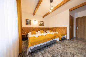 2 łóżka w pokoju hotelowym z żółtą pościelą w obiekcie „Malućko Chata” w Zakopanem