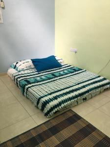 AMMAR FATIMAH HOMESTAY @ MERLIMAU, MELAKA في Merlimau: وجود سرير على الارض في غرفة