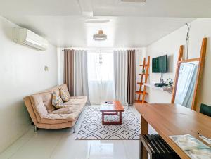uma sala de estar com um sofá e uma mesa em Loft 1BR Condo Cainta near Eastwood Ortigas Fast Wifi em Cainta