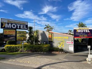 um motel com placas em frente a um parque de estacionamento em Bananatown Motel em Coffs Harbour
