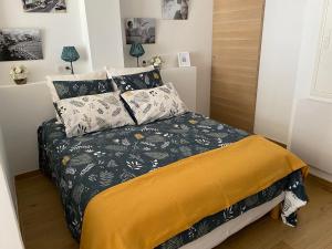 ein kleines Schlafzimmer mit einem Bett mit schwarzer und gelber Bettwäsche in der Unterkunft Studio 30 M2 Hyper centre, Neuf, Parking Gratuit, 3 Étoiles in Cannes