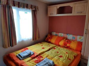 ein Schlafzimmer mit zwei Betten und einem Fenster in der Unterkunft MALLARD in Helming