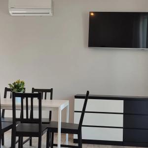 uma sala de jantar com mesa e cadeiras e uma televisão em Apartamenty Wilga em Wilga