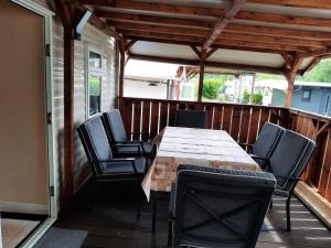 eine Terrasse mit Tisch und Stühlen auf einem Deck in der Unterkunft MALLARD in Helming