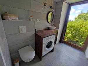 a bathroom with a washing machine and a sink at Conviviale - Longère Lumineuse - Charme & Nature in Bains-sur-Oust