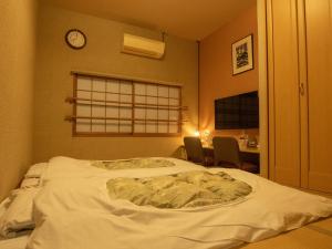 Bett in einem Zimmer mit einer Uhr an der Wand in der Unterkunft Hotel Union in Kagoshima