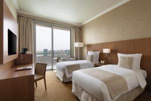 a hotel room with two beds and a large window at Treffen House Doha - next to Msheireb Metro Station and Souq Waqif in Doha