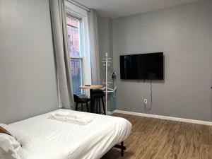 1 dormitorio con 1 cama y TV de pantalla plana en Alina & Fanny - Philadelphia S Broad St, en Filadelfia
