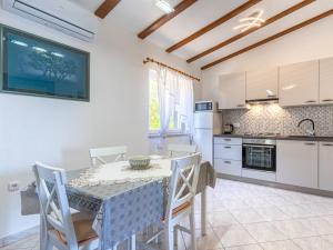 a kitchen with a table and chairs in a room at Merag Sunrise Apartment in Cres
