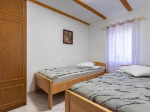 two twin beds in a room with a window at Merag Sunrise Apartment in Cres