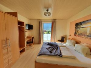 una camera da letto con un letto grande e una finestra di Gasthof Zur Post a Ossiach