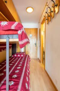 a bedroom with a bed with a red blanket on it at Center of Veysonnaz with a View ! in Veysonnaz