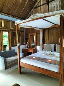 a bedroom with a large bed with a canopy at Friendly Homestay Lemukih in Singaraja