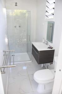 a bathroom with a shower and a toilet and a sink at Kaila Na Ua Resort in Korotogo