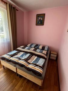 a bed in a room with a pink wall at Apartament Rodzinny in Rumia
