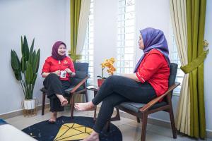 two women sitting in chairs in a room at GHAZRINs DESARU in Pengerang