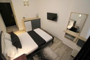 a small bedroom with a bed and a mirror at Jericho Rooms in Sarandë