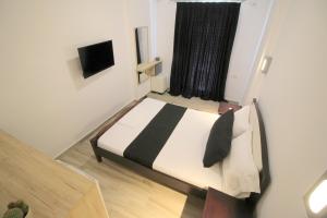 a bedroom with a bed and a television in it at Jericho Rooms in Sarandë