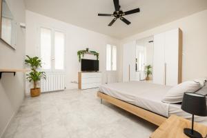 een witte slaapkamer met een bed en een plafondventilator bij [CA 'PICO WITH WIFI]-few steps from center in Mirandola