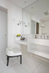 a white bathroom with a sink and a stool at Villa Clarisse in Saint-Martin-de-Ré
