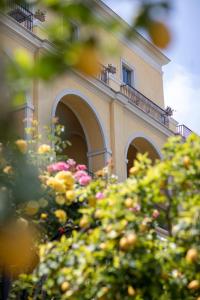 ヴィーコ・エクエンセにあるグランド ホテル アンジョリエーリのバルコニー付きの建物、目の前に花が咲いています。