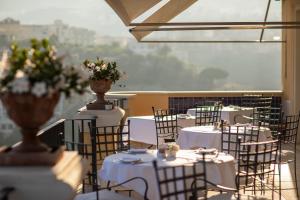 una habitación con mesas y sillas con flores. en Grand Hotel Angiolieri, en Vico Equense