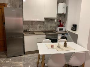 a kitchen with a refrigerator and a table and chairs at -Apartamentos Laguna- in Puerto de Mazarrón +31 photos