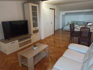a living room with a couch and a flat screen tv at Villa Rea in Malinska