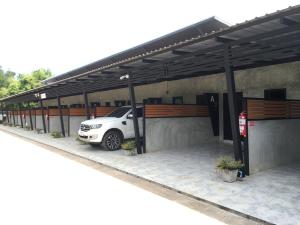 a parking lot with a car parked under a roof at The Loft Resort Kabin Buri in Kabin Buri