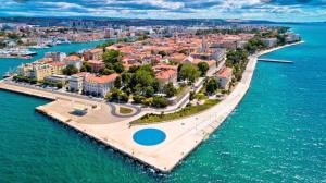 an island in the water next to a city at Letisija in Zadar