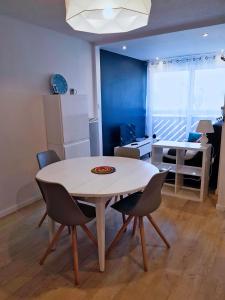 ein Esszimmer mit einem weißen Tisch und Stühlen in der Unterkunft appartement à 300m de la plage in Saint-Georges-de-Didonne