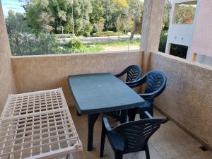 una mesa azul y sillas en un balcón con vistas en Appartement T2 dans résidence avec piscine, en Moriani Plage