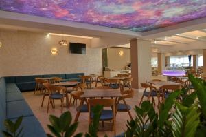 a restaurant with tables and chairs and a purple ceiling at Hotel Opal in Jupiter