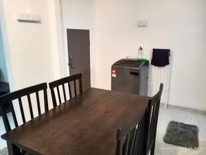 a dining room with a table and a refrigerator at Homestay Ayah Kluang in Kluang