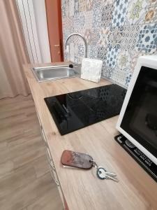 un bancone della cucina con lavandino e chiavi sopra di Cassiopea a Gaeta