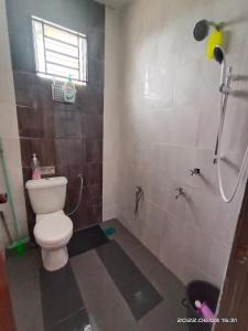 y baño con aseo y ducha. en Homestay Ayah Kluang, en Keluang