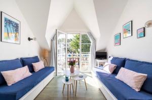 ein Wohnzimmer mit einem blauen Sofa und einem Tisch in der Unterkunft CAP COZ Sea Side FOUESNANT in Fouesnant