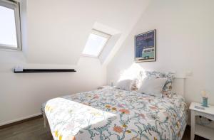 a bedroom with a bed and two windows at CAP COZ Sea Side FOUESNANT in Fouesnant +25 photos