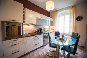 a kitchen with a glass table and a kitchen with white cabinets at Downtown Apartment Nora in Split