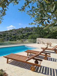 a wooden picnic table next to a swimming pool at Casa sole infinito in Senj