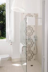 La salle de bains est pourvue d'une douche avec une porte en verre. dans l'établissement Château du Clair de Lune - Teritoria, à Biarritz