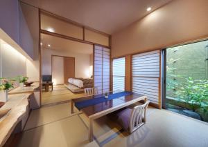 a dining room with a table and a large window at AKARI et KAORI formerly Taizanso in Izu