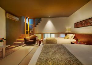 ein Hotelzimmer mit einem Bett und einer Treppe in der Unterkunft AKARI et KAORI formerly Taizanso in Izu