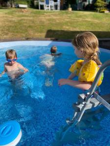 two children in a swimming pool with a boy at Pfälzer LebensArt in Rieschweiler-Mühlbach