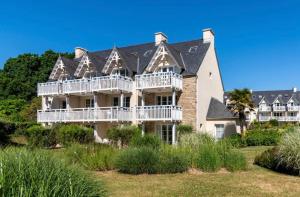 ein großes Haus mit Balkon am Strand in der Unterkunft CAP COZ Sea Side FOUESNANT in Fouesnant