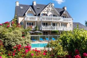 a large house with a swimming pool and flowers at CAP COZ Sea Side FOUESNANT in Fouesnant