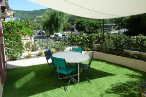 einen Tisch und Stühle auf dem Rasen in der Unterkunft Chez Berni in Millau